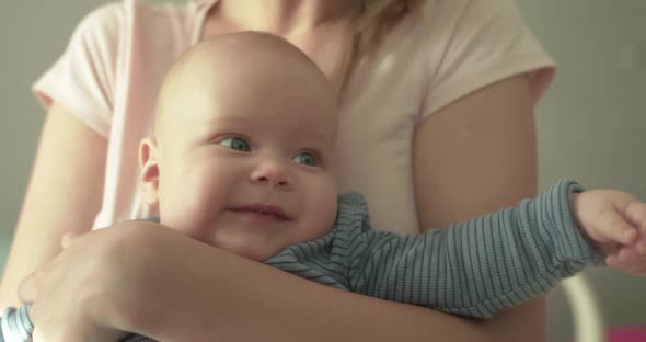 Portrait of Cutie Baby Smiling at Camera on Mother's Hands alt