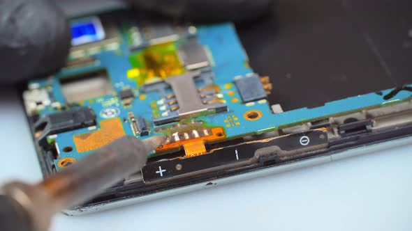 the Master Soldering Iron Solders the Mobile Phone Board with a Soldering Iron alt