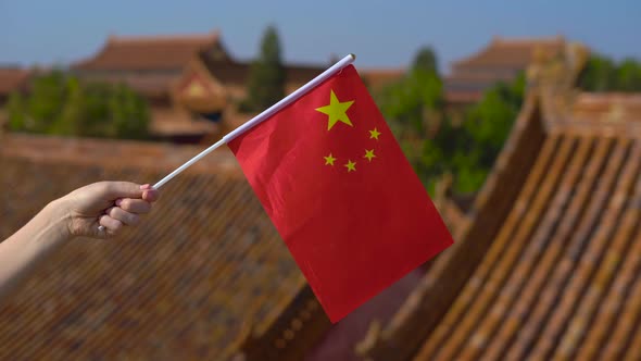 Woman Holding a Small Flag of China in Her Hands. Travel To China Concept alt