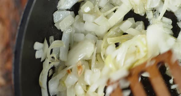 Chopped Onions in the Pan Stir with a Wooden Spatula.  alt