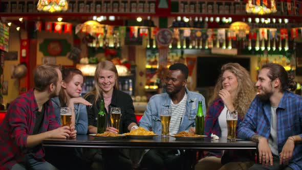 African American with Friends at the Bar Drinks Beer and Eats Chips, Friends Raise Glasses and alt