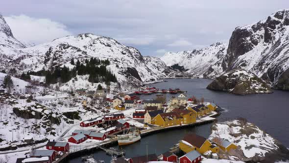Nusfjord Fishing Village and Mountains in Winter. Lofoten Islands, Norway. Aerial View alt