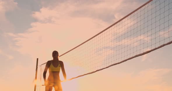 Athletic Girl Playing Beach Volleyball Jumps in the Air and Strikes the Ball Over the Net on a alt