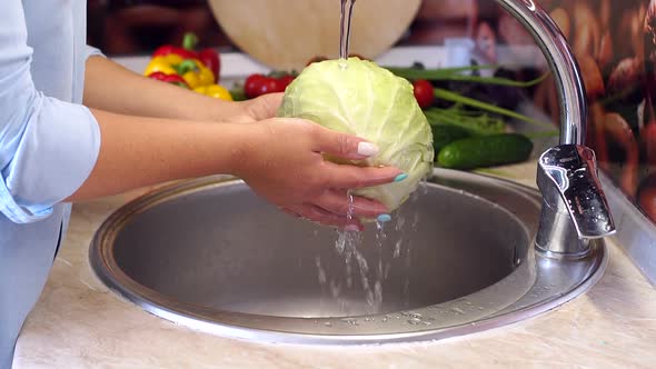 Closeup of Young Woman Washing Fresh Cabbage in Sink Under Running Water alt