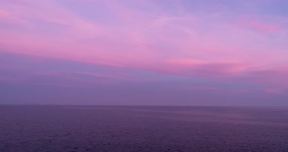 4k drone video flight over ocean, sea at beautiful purple sunset. Close to the water alt