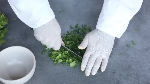 Chef cuts with knife parsley,dill and cilantro