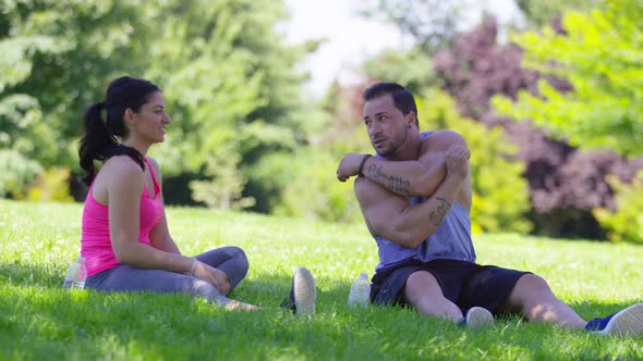 Athletic couple at park stretching before run