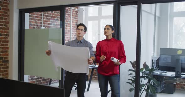 Man and woman with plan document discussing and shaking hands at office alt
