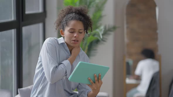 Young Confident African American Woman Using Virtual Conference on Tablet with Blurred Reflection of alt
