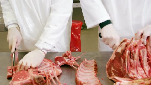 Butchers slicing red meat alt