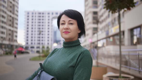 Portrait of a Woman in the City Posing on Camera Looking at the Camera and Smiling