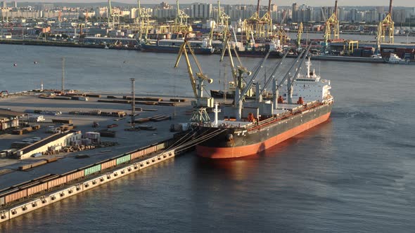 Sea port terminal with cranes. Cargo ship is waiting for loading. Aerial view.