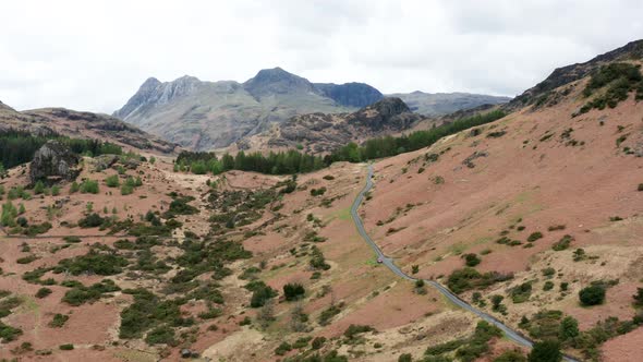 Aerial View Over Hills Towards Mountains