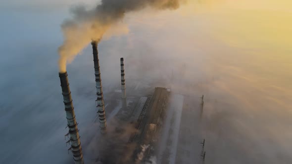 Aerial view of coal power plant high pipes with black smoke moving up polluting atmosphere alt