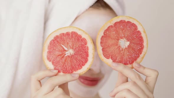 Smiling Young Cute Girl with a White Towel on Her Head and White Nutritious Mask on Her Face Hiding alt