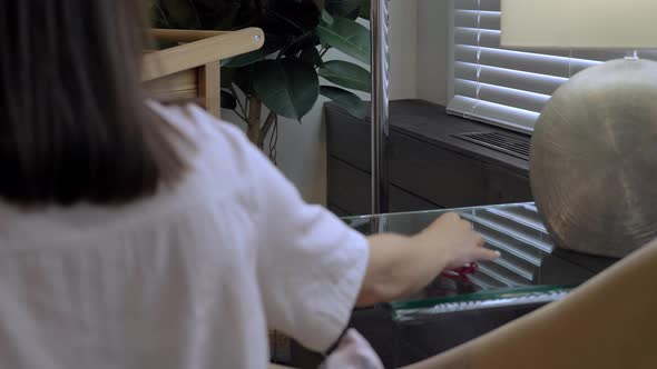 Young Attractive Caucasian Woman Takes Glasses From Table While Sitting in the Room alt