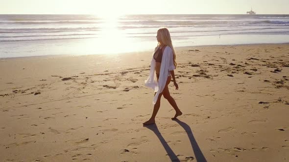 Attractive Blond Woman Walking on the Beach alt