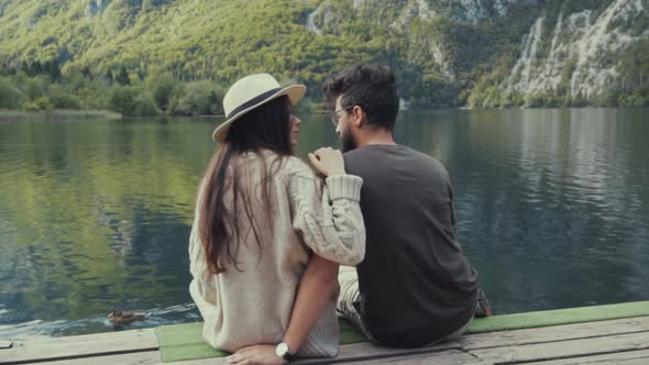 Couple sitting on pier alt