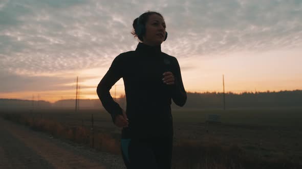 Sporty Female Jogger Is Running and Training Outside at the Nature. Athletic Woman Is Running During alt