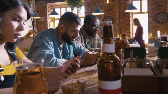 Serious people sitting at bar counter with telephones