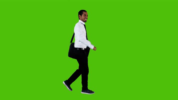 happy businessman walking and looking around over a green background greeen background