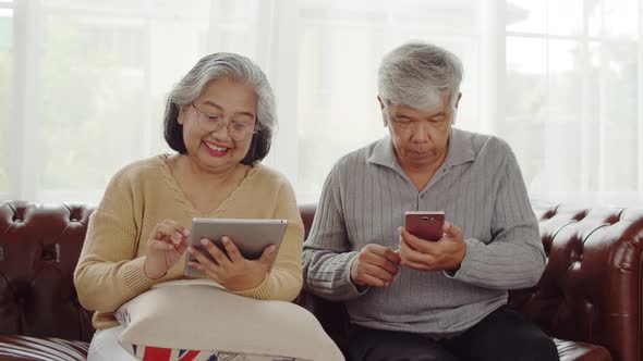 Senior couple using technology device at home alt