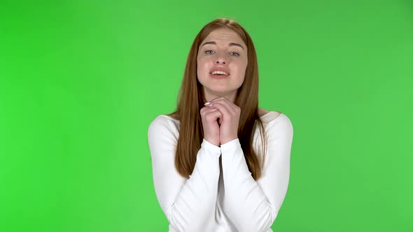 Portrait of Pretty Young Woman Is Keeping Palm Together and Asking for Something alt