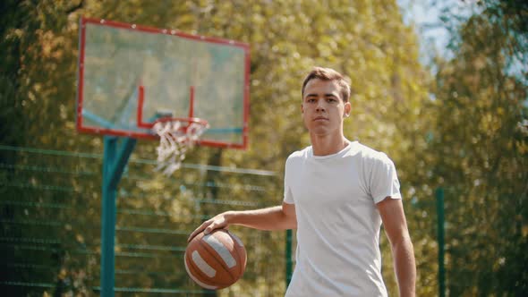 A Man Standing on a Sports Ground and Stuff the Basketball Ball alt