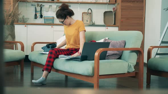 Workimg From Home During Coronavirus Pandemic. A Woman in Leisure Wear Is Working From Home alt