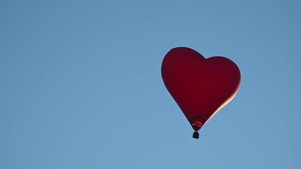 Colorful Hotair Heart Shape Balloon Flying on Sunset Over Blue Sky in Slow Motion Happy Valentines alt