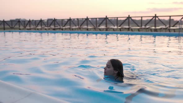 Girl in Leopard Swimsuit Playing in the Pool Under the Summer Sun alt
