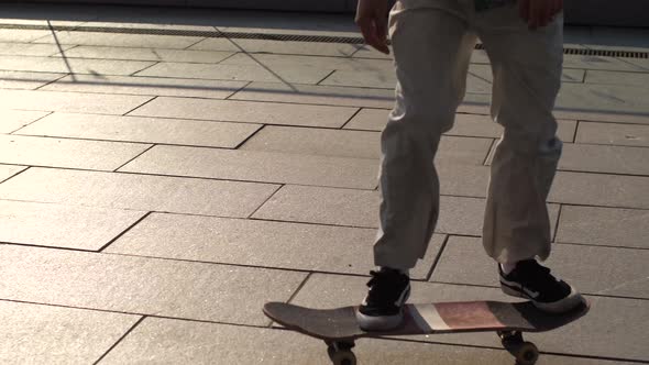 Feet of Man Skater Making Ollie Trick From Bank alt