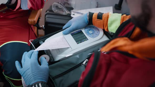 Crop Paramedics Doing ECG Test in Ambulance alt