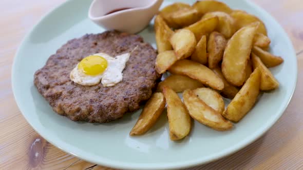 on a White Plate Cutlet, Omelet and Potato Wedges. Business Lunch. Lunch in a Cafe