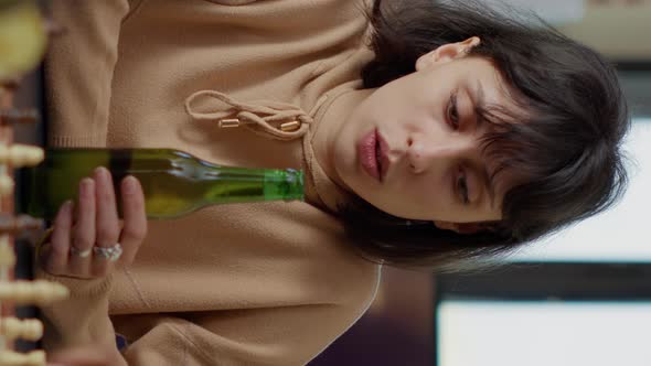 Vertical Video Portrait of Happy Woman Raising Beer Bottle in Front of Camera alt