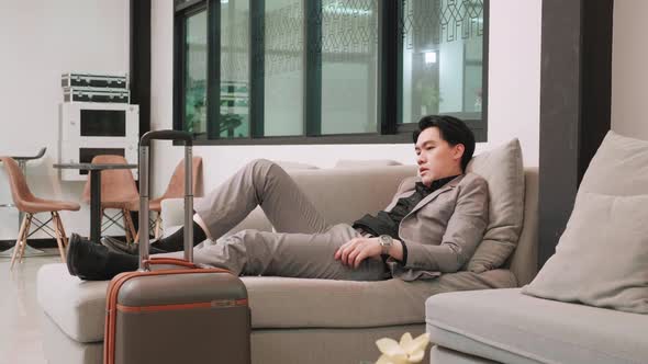 Businessman sleep on sofa at boarding lounge of airline hub, rushing to Boarding, business trip