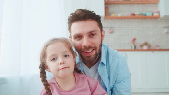 Young family talking on an online conference with mom using a laptop alt