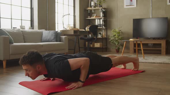 Young Caucasian Man Doing Floor Pushups at Home in Living Room alt