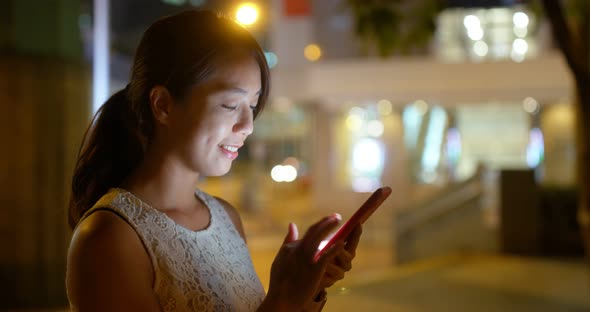 Woman use of mobile phone online at night alt