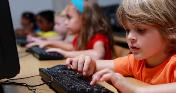 Little boy smiling at camera during computer class alt
