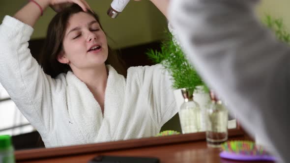 4k A pretty girl are singing while using the hair dryer, enjoing her life alt