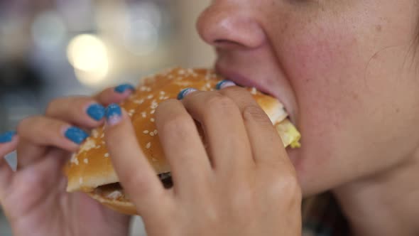 Young Hungry Woman Biting Vegan Meatless Burger in Fast Food Restaurant. Girl Eating a Hamburger
