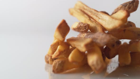 French fries falling on white surface. Slow Motion. alt