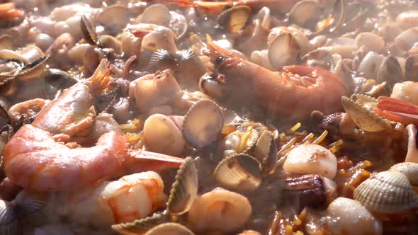 Cooking a delicious paella, shrimp, seafood, lobster. alt