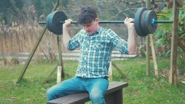 Home gym weight training young man doing military and behind neck press alt