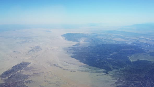 High altitude aerial flying over the desert on a bright sunny day. alt