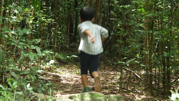 Boy running and playing in forest alt