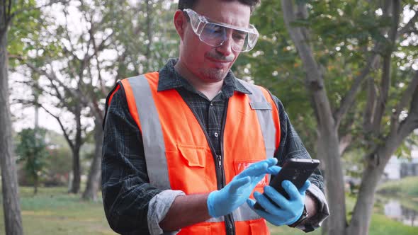 Biological engineer use smartphone doing working at site