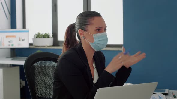 Businesswoman with Medical Face Mask Talking with Her Team About Communication Strategy alt