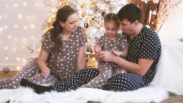 Beautiful Happy Family with Child Sitting Together in Christmas Interior